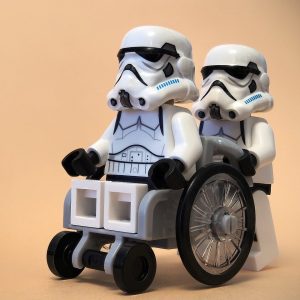 휠체어를 탄 사람과 밀어주는 사람 (영화 스타워즈의 스톰트루퍼 장난감) 휠체어를 탄 사람과 밀어주는 사람 (영화 스타워즈의 스톰트루퍼 장난감)